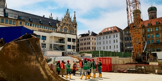 Personen mit Helmen und Warnwesten auf der Baustelle Marienhof