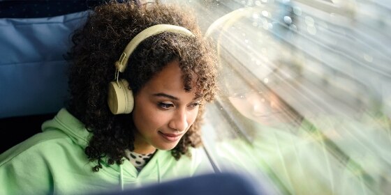 Junge Frau mit Kopfhörer, hört Musik, entspannt.