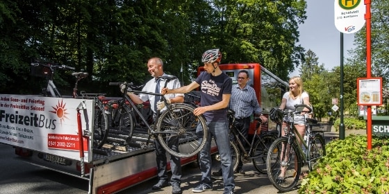 Kunden mit Fahrrad vor Bus