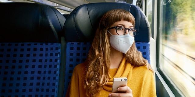 Frau im Regiozug mit FFP2-Maske