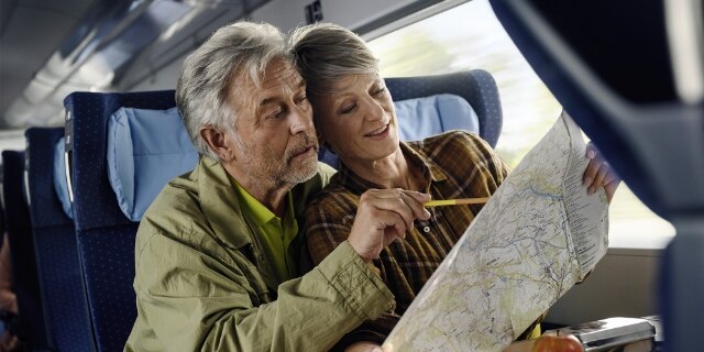 Senioren mit Ausflugs-Ausstattung studieren Wanderkarte.