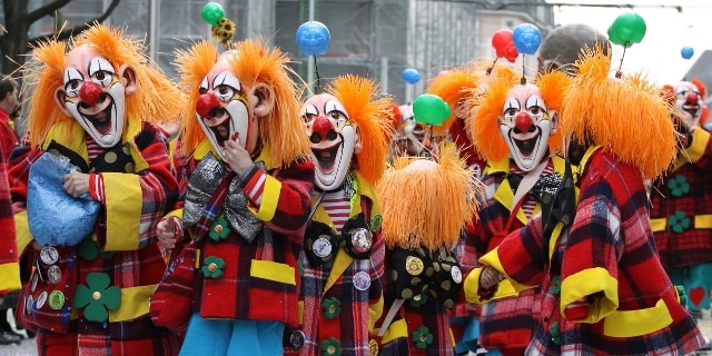 Als Clown maskierte Menschen beim Fasnachts-Umzug