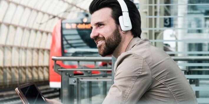 Mann mit Kopfhörer am Bahnsteig