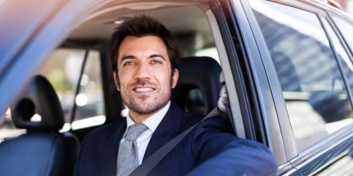 Smiling business man driving his car 