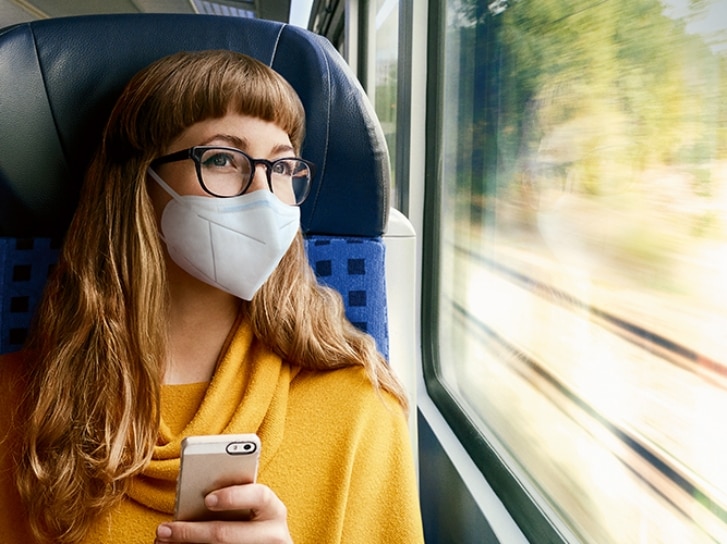 Frau mit FFP2-Maske im Regiozug