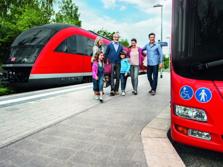 Fahrgäste steigen um von Zug in Bus
