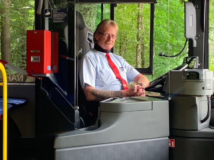 Busfahrer hinter Plexiglasscheibe