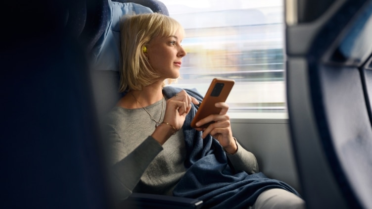 Frau mit Smartphone im Zug.