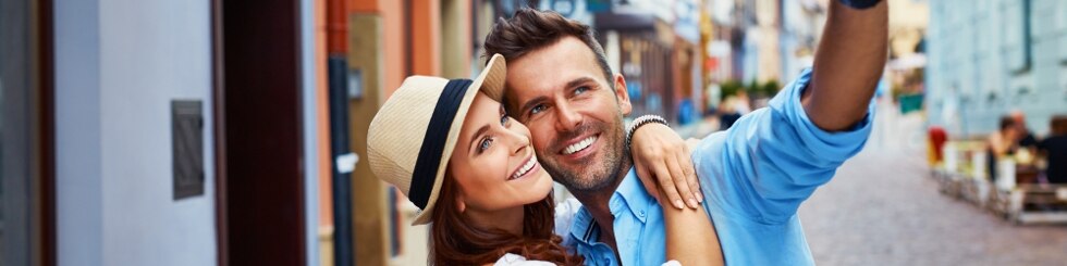 Happy couple of tourists taking selfie in old city