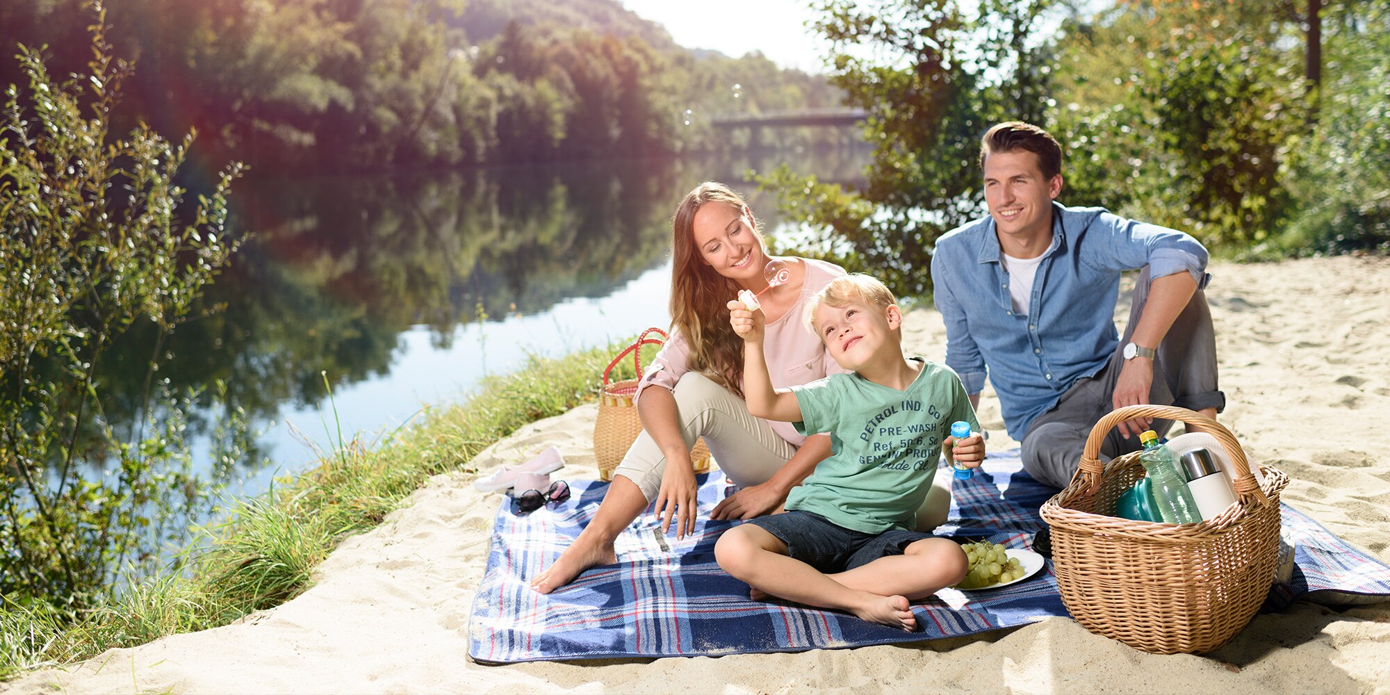 Familie beim Picknicken am Traunufer. Wels, Oberösterreich.