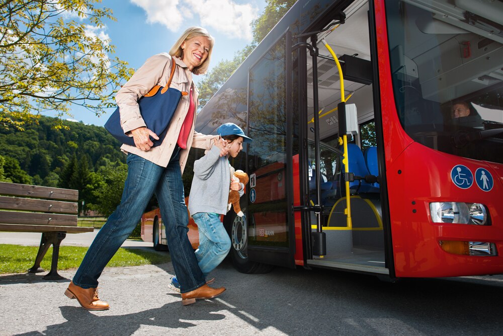 Frau steigt mit Junge in Bus